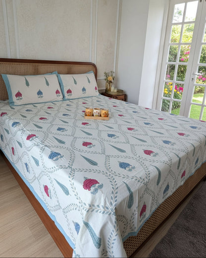 Tarangini blue lotus cotton bedsheet with matching pillow covers in a garden-facing bedroom