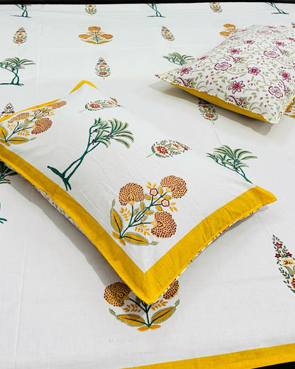 Floral patterned bedspread with yellow accents on a bed