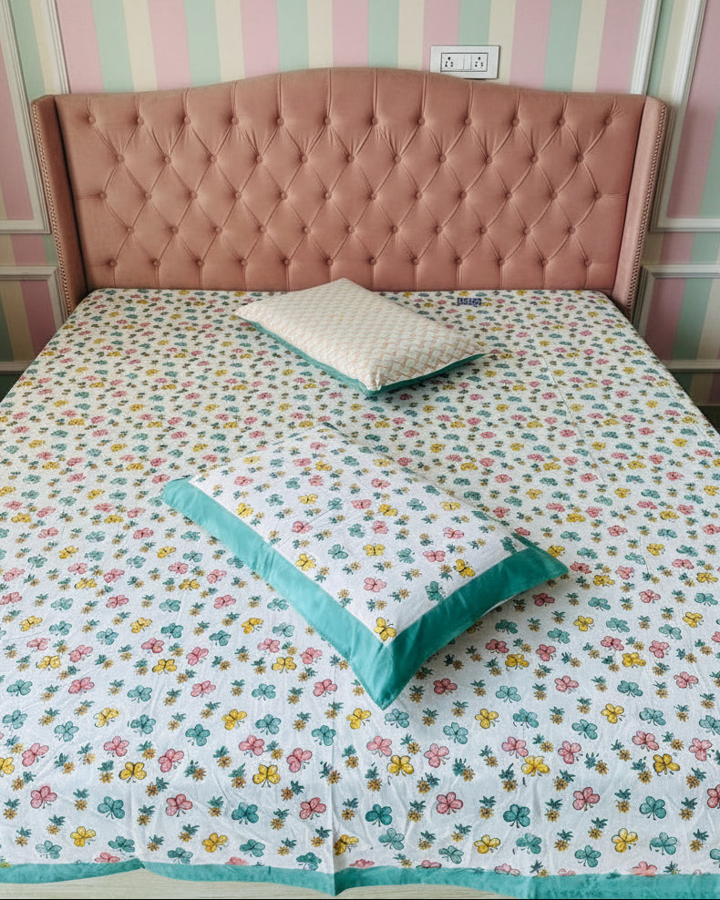 Bed with floral bedding and wooden headboard in a room.
